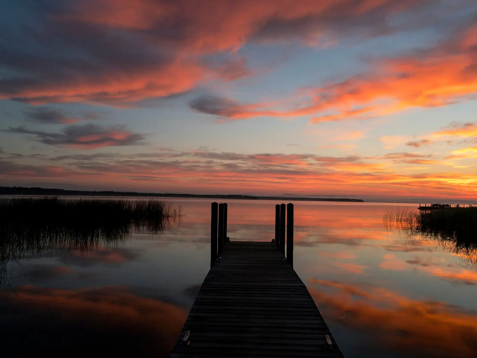 black wooden dock on body of water during golden hour jigsaw puzzle