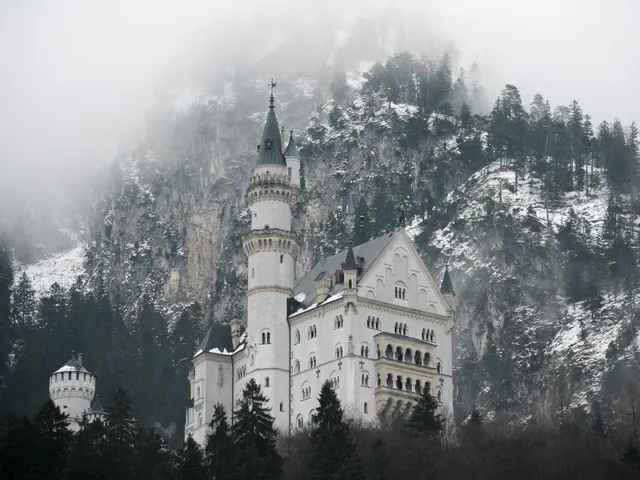 white concrete castle below mountain covered with tree during daytime jigsaw puzzle